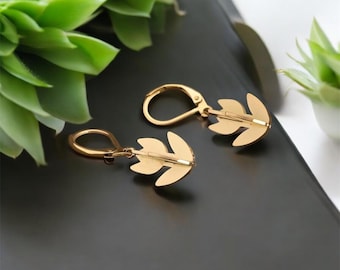 May include: Gold leaf earrings with a simple design. The earrings have a hook closure.