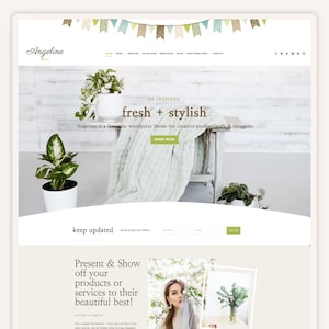 May include: A website homepage for a feminine WordPress theme called Angeline. The website features a green and white color scheme with a banner of flags at the top. The text "fresh + stylish" is displayed in a brown font. The website is designed for creative professionals and bloggers.
