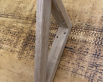 May include: A light wood triangular shelf bracket with three pre-drilled holes.