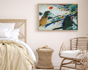 Puede incluir: Una pintura abstracta en un marco dorado cuelga sobre una cama con una manta beige. La obra de arte presenta un sol rojo y pinceladas coloridas. Una mesa auxiliar y una silla de mimbre completan la decoración de la habitación.