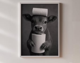 May include: Black and white framed print featuring a calf holding a roll of toilet paper and another roll balanced on its head. The North Gallery logo is in the bottom right corner. The image has a soft, neutral background.