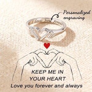 May include: A silver ring in the shape of two hands forming a heart, engraved with "I love you forever." Below, a red heart and a drawing of hands create a heart shape. Text reads "Keep me in your heart, Love you forever and always."