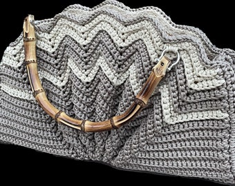 Könnte beinhalten: Eine gehäkelte Handtasche mit einem braunen und weißen Chevron-Muster und einem Griff aus natürlichem Bambus.