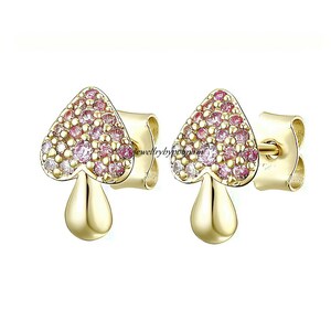 Puede incluir: Un par de pendientes de oro en forma de hongo con detalles de cristal rosa y blanco.
