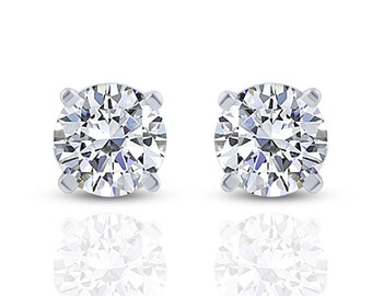 May include: A pair of round-cut diamond stud earrings. Each earring features a sparkling, clear diamond set in a four-prong silver or white gold setting. The earrings are displayed on a white background with a slight reflection.