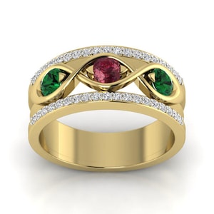 May include: A yellow gold ring featuring a central round red gemstone flanked by two oval green gemstones. The band is designed with an infinity-style motif and is accented with two rows of small white pavé-set stones along the top and bottom edges.