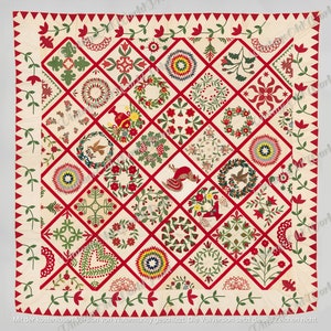 May include: A red, white, and green patchwork quilt with a variety of floral and geometric designs. The quilt is made up of 36 individual squares, each with a different pattern. The quilt is surrounded by a red border with a white and green vine pattern.