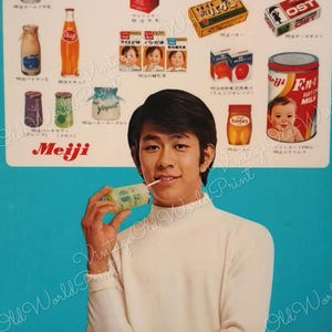 May include: A vintage advertisement for Meiji dairy products featuring a young man drinking a glass of milk. The ad features a variety of Meiji products, including milk, yogurt, juice, and baby formula. The text on the ad is in Japanese.