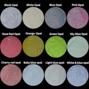 May include: A grid of twelve circular samples of opal material in various colours including black, white, blue, pink, rose red, orange, green, sky blue, cherry red, baby blue, light blue, and white and blue, each labelled with its colour name.
