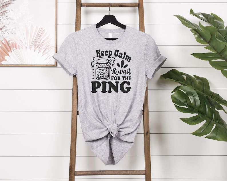 May include: Gray t-shirt with a black graphic that says "Keep Calm & Wait for the PING" and a drawing of a jar of pickles.