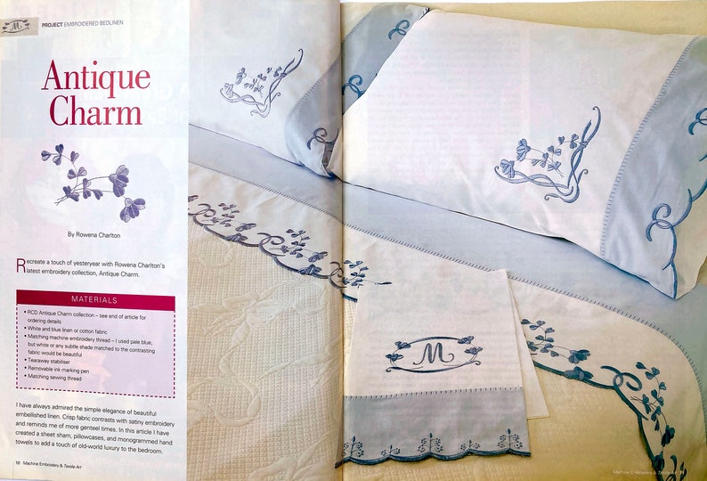 White pillowcases and sheets set on a bed. The pillowcases and sheets have blue edging and embroidered monograms.