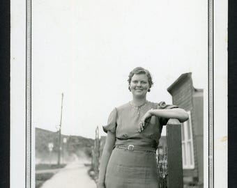 Vintage fotomomentopname jaren 1930 lachende vrouw op stoep leunend op hek Post Fashion