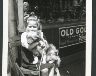 Girl on Chair Holding Small Furry Terrier Dog in Front of Storefront Grocery Original Vintage Photo Snapshot 1940s Fashion