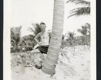 Schlanker, hemdloser Mann, der sich auf einen Palmen-Badeanzug stützt, Original-Vintage-Foto-Schnappschuss, 1940er-Jahre-Mode, Sommerstrand