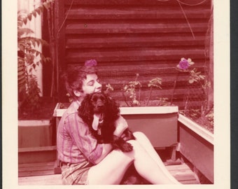 Coupe de cheveux de lutin de femme heureuse câlins mignon chien épagneul noir dans un jardin de fleurs de terrasse au milieu du siècle photo vintage instantané des années 1950 animaux de compagnie adorent 2