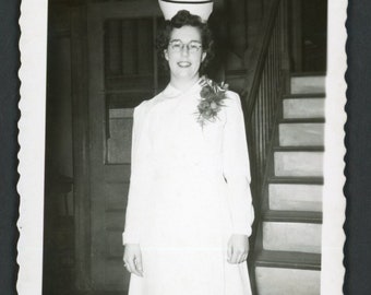 Lächelnde junge Krankenschwester, weiße Uniform, hoher Hut, Korsage, Brille, Original-Vintage-Schnappschussfoto, Mode aus den 1940er Jahren, Gesundheitspflege, Krankenpflege
