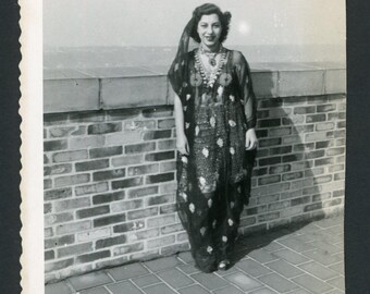 Vintage fotomomentopname 1950: lachende vrouw draagt harembroek danskostuum in boho-modestijl