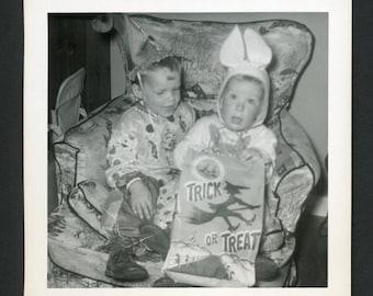 Vintage foto uit de jaren 1950: kinderen in Halloweenkostuums met een snoepzak.
