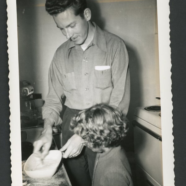 Cooking With Dad! Man Stirring Bowl While Daughter Girl Looks On Kitchen Vintage Photo Snapshot Family Children Suburbia 1950s Fashion