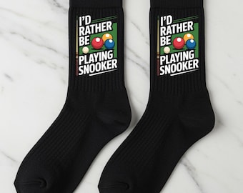 May include: Pair of black crew socks with the text "I'd Rather Be Playing Snooker" and a graphic of snooker balls. The socks are made of a soft, ribbed material and are designed for comfort and style.