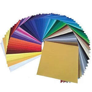 May include: A fan-shaped assortment of 40 sheets of adhesive vinyl in various colors, including red, blue, green, yellow, and black. The vinyl sheets are arranged in a semi-circle, with a single gold sheet in the center.