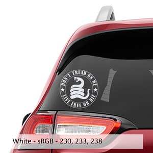 以下が含まれることがあります： 赤い車のリアウィンドウに貼られた、蛇と「Don't Tread On Me Live Free Or Die」という文字が円形に書かれた白いビニールステッカーです。