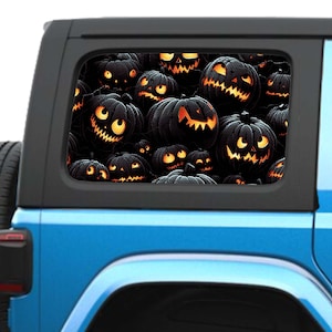 Puede incluir: Un adhesivo perforado para ventana aplicado en la ventanilla lateral trasera de un vehículo azul. El gráfico presenta un patrón repetitivo de calabazas negras con ojos naranjas brillantes y bocas dentadas, creando una decoración de Halloween.