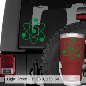 Puede incluir: Un vaso YETI rojo con un dise&ntilde;o de s&iacute;mbolo de &aacute;tomo verde. El vaso est&aacute; en un coche negro con una pegatina de s&iacute;mbolo de &aacute;tomo verde en la ventana trasera. Verde claro - sRGB 0, 135, 60