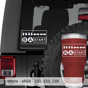 May include: A white decal and a red tumbler featuring a gaming-inspired design. The design includes directional arrows, the letters "B" and "A", and the word "START" within a rectangular frame. The tumbler has the "YETI" logo.