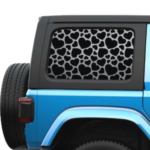 Puede incluir: Un Jeep Wrangler azul con una calcomanía de ventana de patrón de corazón negro. La calcomanía cubre toda la ventana trasera.