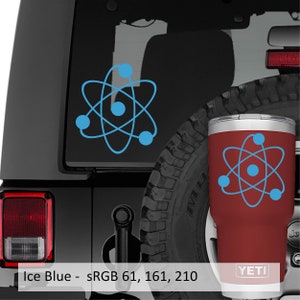 Puede incluir: Un vaso YETI rojo con un dise&ntilde;o de &aacute;tomo azul. El vaso est&aacute; en un coche negro con una pegatina de &aacute;tomo azul en la parte trasera.