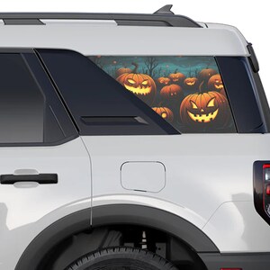 May include: White SUV with a rear window decal of orange jack-o'-lantern pumpkins with spooky faces.