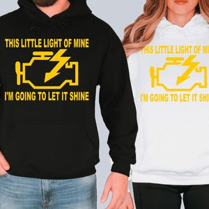 May include: A white ceramic mug with a black handle and the text "But First, Coffee" in a bold, black font. The mug is on a wooden surface. The mug is approximately 10 cm tall.