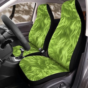 May include: Bright green, shaggy car seat covers. The covers have a black border and are installed in a car. The steering wheel and gear shift are visible in the image. The seat covers have a furry texture.