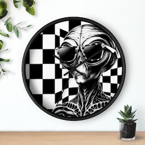 May include: Black and white clock featuring a stylized alien wearing sunglasses against a checkered background.