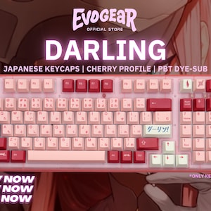 May include: A keyboard with Japanese keycaps, Cherry profile, and PBT dye-sub. The keys are a mix of pink and white with Japanese characters. The word "DARLING" is displayed above the keyboard.