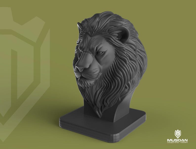 May include: A dark grey lion head sculpture on a square base. The lion's mane and facial features are intricately detailed. The sculpture is set against a muted green background with a logo in the bottom right corner.