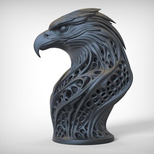 May include: A dark gray sculpture of an eagle's head. The eagle's head is detailed with textured feathers and a curved beak. The neck has an open, web-like design. The sculpture is mounted on a circular base.