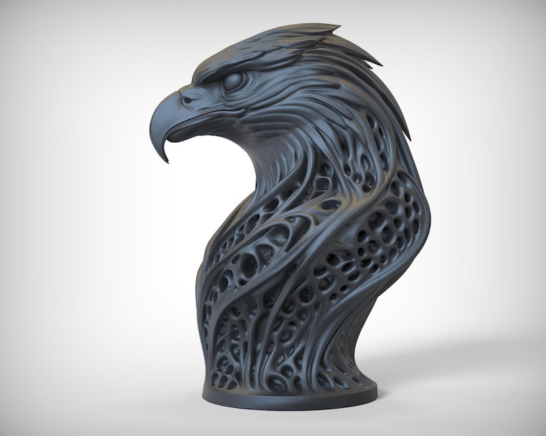 May include: A dark gray sculpture of an eagle's head. The eagle's head is detailed with textured feathers and a curved beak. The neck has an open, web-like design. The sculpture is mounted on a circular base.