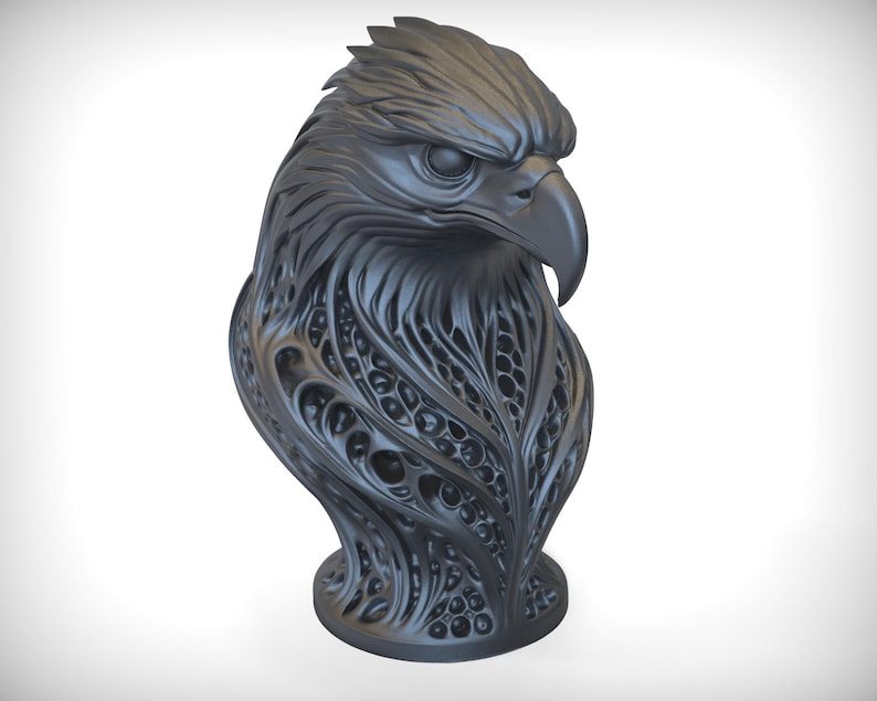 May include: A dark gray sculpture of an eagle's head and upper body. The eagle's feathers and body are intricately detailed with a flowing, organic pattern. The sculpture has a smooth, matte finish and sits on a round base.