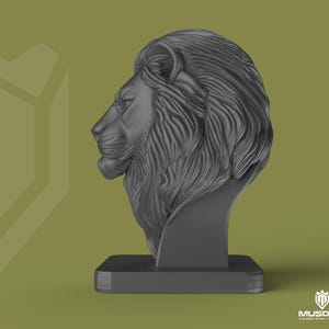 May include: A dark grey lion head sculpture, depicting the animal's profile. The sculpture is mounted on a rectangular base. The lion's mane is detailed, and the design is modern and artistic.