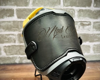 May include: Black leather motorcycle boot with a gray and black sole. The boot has a yellow strap and a Mad Ox Leather logo embossed on the side.