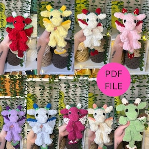 May include: A collection of handmade crochet dragon plushies in various fruit-inspired colors, including red watermelon, yellow lemon, white cherry, and pink strawberry. The image also includes a pink circle with the text "PDF FILE".