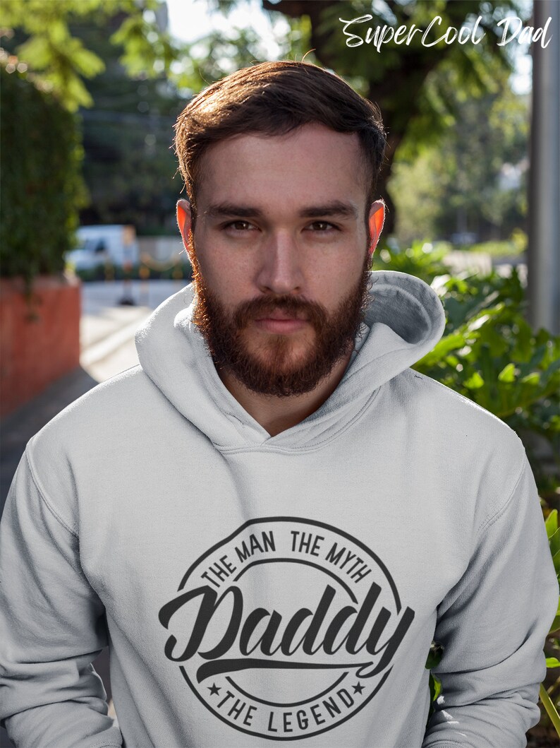 May include: A gray hooded sweatshirt with a black circle graphic that says "The Man The Myth Daddy The Legend".