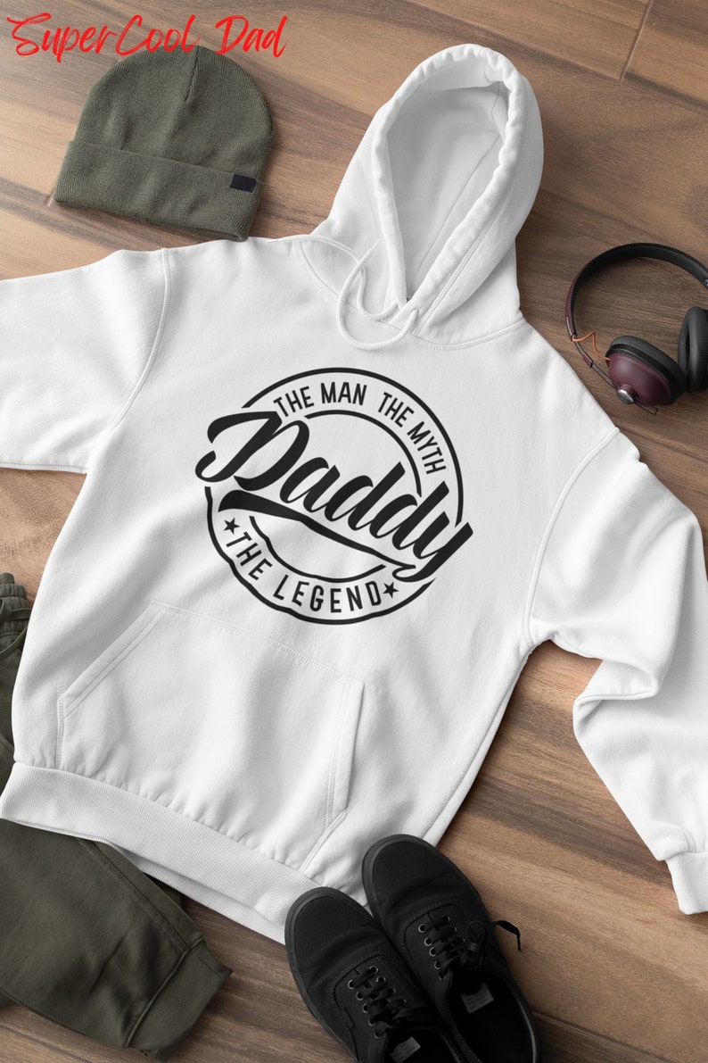 May include: White hooded sweatshirt with a black circle graphic that says "The Man The Myth Daddy The Legend".