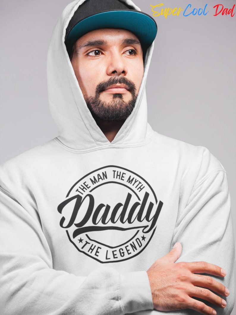 May include: A white hooded sweatshirt with a black circle graphic that says "The Man The Myth Daddy The Legend".