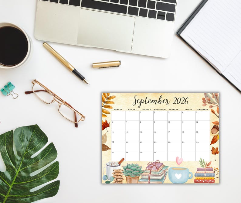 May include: A desk calendar for September 2026 with a watercolor design. The calendar features a cream-colored background with autumn leaves and decorative elements. A cup of coffee, a pen, and glasses are on the desk.