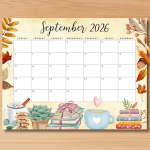 May include: A watercolor-style September 2026 calendar with a warm, autumnal theme. The calendar grid is set against a beige background with decorative elements like leaves, books, and mugs. Colored pencils are placed on the right side.