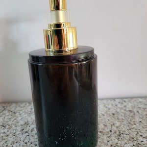 Un distributeur de savon entièrement fait en résine epoxy avec une pompe qui se dévisse facilement pour le remplir à nouveau Noir avec reflets