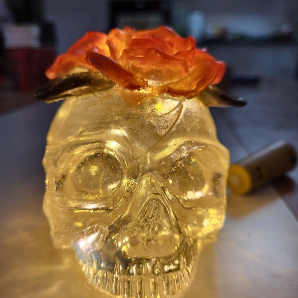 Une tête de mort avec trois roses sur le dessus du crâne avec la possibilité de l'illuminer grâce à une guirlande LED intégrée